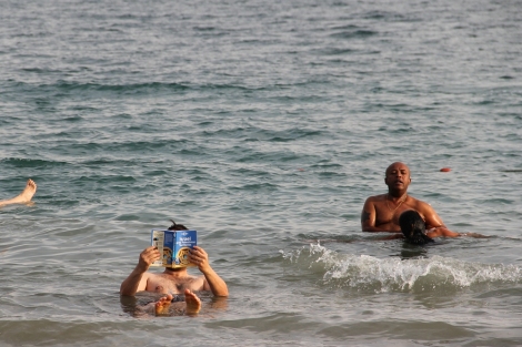 reading the guide book while floating in the Dead Sea